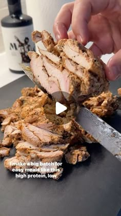 a person cutting meat with a knife on top of it