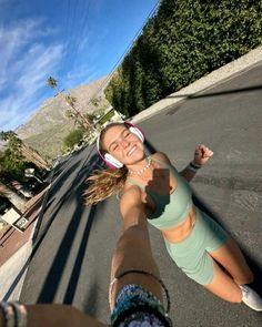 a woman is taking a selfie in the middle of the street with her hand up