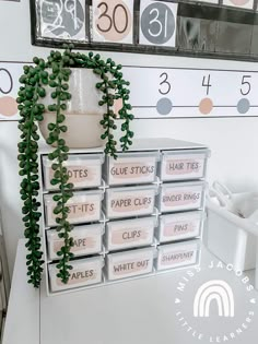 a white table topped with lots of boxes filled with paper cups and plant growing out of it