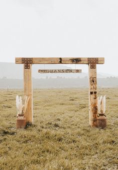 two wooden pillars in the middle of an open field