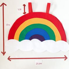 a felt rainbow with clouds on the bottom and an arrow pointing up to it's center