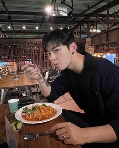 a man sitting at a table with a plate of food