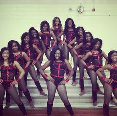 a group of women in black and red outfits