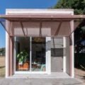 a small pink building sitting in the middle of a park