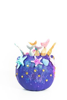 a purple ball with stars and mermaids on it's side, sitting in front of a white background