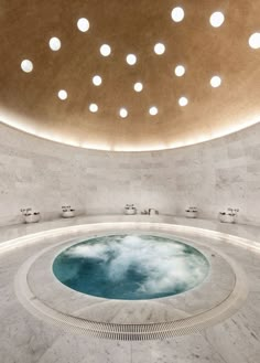 an indoor hot tub in the middle of a room with round lights on the ceiling