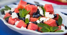 watermelon, blueberries and mint salad in a white bowl on a table