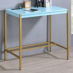 a blue desk with gold legs and a clock on it's shelf next to a window