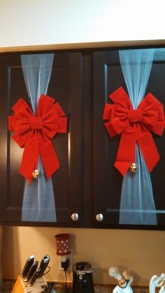 two cabinets with bows on them in a kitchen