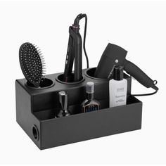 a hair dryer, comb and other items in a black holder on a white background