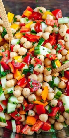 a salad with chickpeas, carrots, cucumbers and parsley