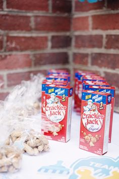 crackers jack are sitting on a table next to some bags of peanuts and other snacks