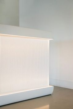 a large white sculpture sitting on top of a floor next to a wall in a room