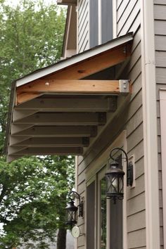 an outside view of a house with some lights on the porch and a lamp post