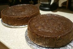 two chocolate cakes sitting on top of a counter