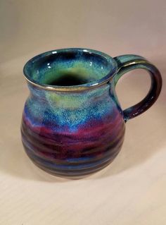 a blue and purple mug sitting on top of a table