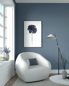 a living room painted in blue and white with a large flower painting on the wall