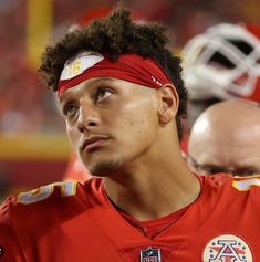 a close up of a football player wearing a bandana and looking off to the side