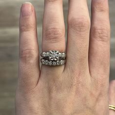 a woman's hand with two wedding rings on it