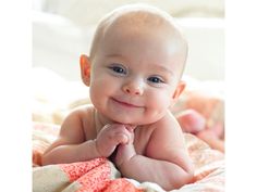 a smiling baby laying on top of a bed next to a quote that says, kak a bac beck