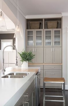 a kitchen with white counter tops and stainless steel appliances on the wall next to an island