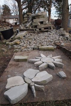 a pile of rocks sitting on top of a cement slab in the middle of a yard