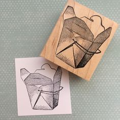 a rubber stamp with an origami figure on it next to a piece of paper