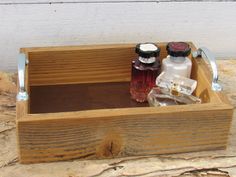 an empty wooden box with two bottles in it sitting on top of some wood planks