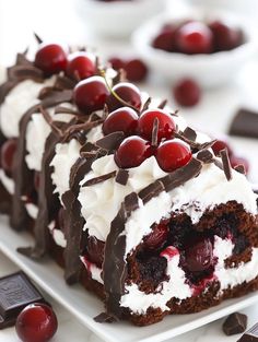 a piece of cake on a plate with cherries