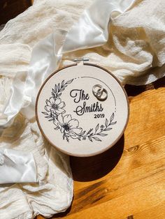 the wedding ring is on top of an embroidered hoop