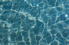 clear blue water in a pool with ripples and sun reflecting on the water surface