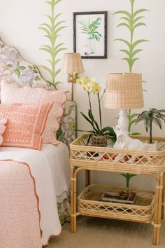 a bedroom with two lamps and a wicker side table