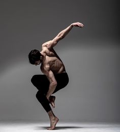 a shirtless man doing a split in the air