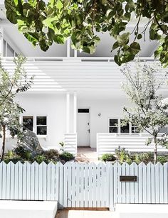 a white house with trees in front of it