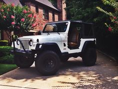 a white jeep parked in front of a house