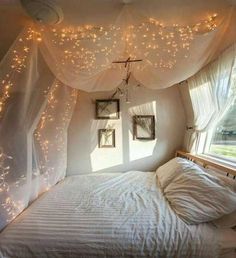 an image of a bedroom with lights on the ceiling and curtains over the bed,