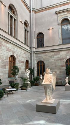 an indoor courtyard with statues and tables