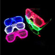 two neon glasses sitting next to each other on a black surface with one glowing in the dark