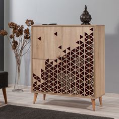 a wooden cabinet with geometric designs on the front and sides, in a living room