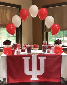 a table topped with red and white balloons