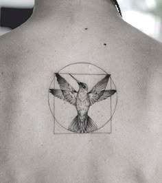 the back of a man's neck with a bird in a circle tattoo on it