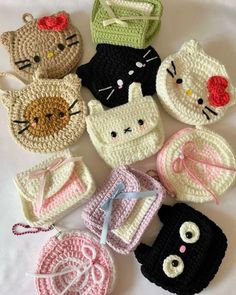 there are many crocheted hats and purses on the bed with white sheets