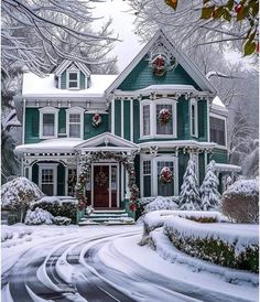 a large green house with wreaths on the front door and windows covered in snow