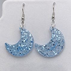 Light Baby Blue Sky Blue Sparkle and Glitter Dangle Earring Moon Shape Trendy Glamor Fashion Statement - Gender Reveal Gift by CypressWoodsArt on Etsy Cute Blue Round Jewelry, Blue Crescent Earrings As A Gift, Celestial Blue Earrings For Party, Blue Resin Jewelry For Party, Blue Resin Jewelry For Parties, Blue Celestial Hypoallergenic Jewelry, Sparkling Blue Earrings For Gift, Blue Round Earrings With Moon Charm, Handmade Blue Celestial Earrings