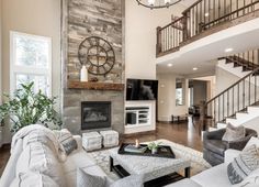 a living room filled with furniture and a fire place in front of a tv mounted on a wall