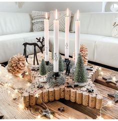 a table topped with candles surrounded by christmas decorations and pine cones on top of wooden slices