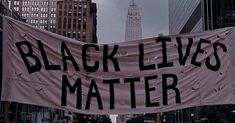 a banner that says black lives matter on the side of a building in new york city