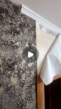 the wall paper has been torn off and is next to a white piece of cloth