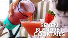 a woman pouring a drink into a glass with a strawberry on the rim next to it