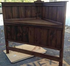 a wooden bed frame sitting on top of a piece of plywood